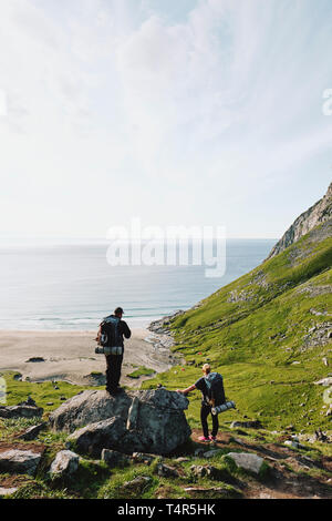 Randonneurs sur le sentier de la plage de Kvalvika sur la côte nord-est de l'Moskenesøya in Flakstad îles Lofoten Nordland en Norvège. Banque D'Images