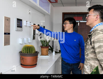 (190418) -- URUMQI, 18 avril 2019 (Xinhua) -- Sun Houxing (L), la troisième génération de personnes travaillaient dans le Xinjiang, introduit des dispositifs de sécurité intelligents de son entreprise à un incubateur d'entreprises dans la base de Shihezi, nord-ouest de la Chine, la Région autonome du Xinjiang Uygur, 10 avril 2019. Shihezi, quelque 150 kilomètres au nord-ouest d'Urumqi, est une ville jeune qui a été créé dans les années 1950 dans le désert de Gobi de Xinjiang. Grâce à plusieurs générations d'efforts des gens du Xinjiang et le Xinjiang Production et construction Corps, c'est devenu une belle ville et développé dans la région autonome. L'urba Banque D'Images