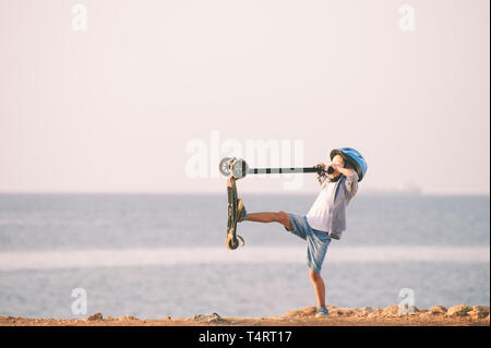 Petit garçon active jouant avec scooter sur mer en été sport loisirs location Banque D'Images