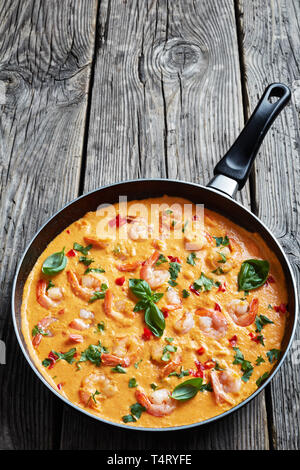 Crevettes en sauce crémeuse à la noix de coco mélangé avec des légumes et fines herbes, camarao pas de leite de coco, recette brésilienne, vue verticale de ci-dessus, close-up Banque D'Images