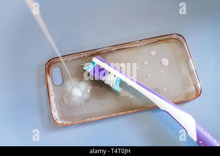 Nettoyage de la brosse à dents avec cas téléphone silicone, mousse et savon Banque D'Images