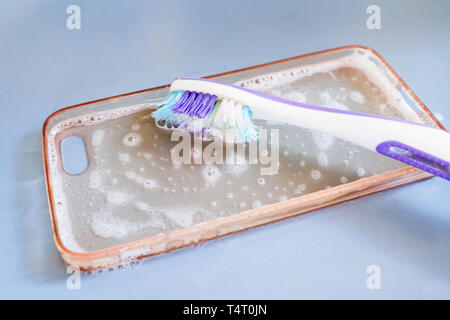 Nettoyage de la brosse à dents avec cas téléphone silicone, mousse et savon Banque D'Images