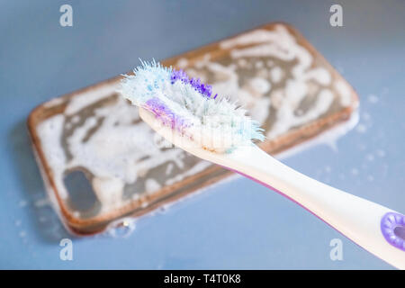 Nettoyage de la brosse à dents avec cas téléphone silicone, mousse et savon Banque D'Images