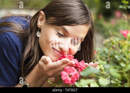 Young woman smelling roses, Allemagne Banque D'Images