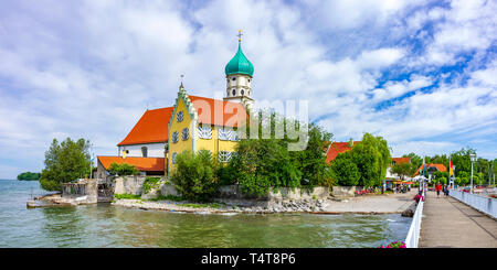 Vue de Saint George's Church et la jetée avec les touristes à Wasserburg au lac de Constance, Bavière, Allemagne. Banque D'Images