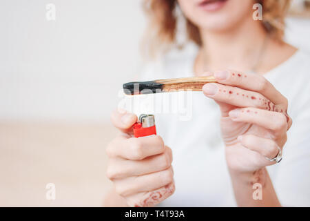 Palo santo ou Bursera graveolens. Jeune femme blonde stick allume bois saint, Close up Banque D'Images