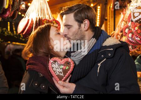 Un couple s'embrasser sur un marché de Noël, coeur d'épices avec dire "ich liebe dich", l'Allemagne, de l'Europe Banque D'Images