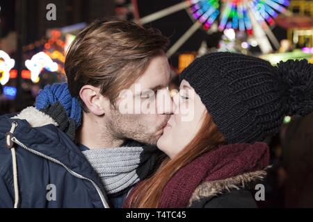 Un couple s'embrasser sur un marché de Noël, l'Allemagne, de l'Europe Banque D'Images