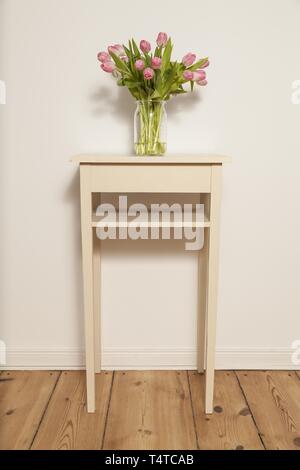 Bouquet de tulipes en verre sur un tabouret Banque D'Images