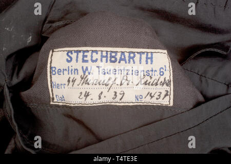 La COLLECTION JOHN PEPERA, une soirée Robe Veste de SS-Sturmbannführer Dr Lüdcke sur mesure, de laine noire doeskin double-breasted taille Veste avec col ouvert et Revers en soie noire, argent/aluminium garniture cordon sur le col et poignets, argent/aluminium boutons avec les runes et couronne en relief levé. Collier laine noir tabs bordé d'argent/aluminium, cordon lisse sur le côté droit, rang 4 pips sur la gauche. Argent/aluminium interwoven épaulettes cordon noir sur fond rouge de la laine, de la laine et soie gros-grain, bordés de brassard cordon argent/aluminium, un vieux Fighter's chevro, Editorial-Use-seulement Banque D'Images