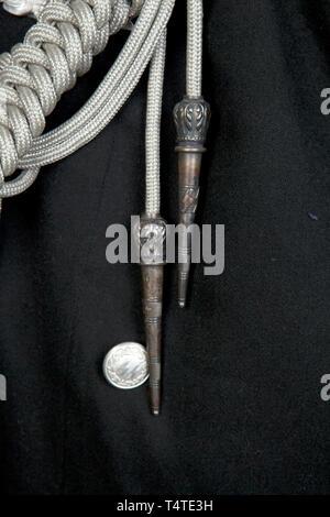 La COLLECTION JOHN PEPERA, une soirée Robe Veste de SS-Sturmbannführer Dr Lüdcke sur mesure, de laine noire doeskin double-breasted taille Veste avec col ouvert et Revers en soie noire, argent/aluminium garniture cordon sur le col et poignets, argent/aluminium boutons avec les runes et couronne en relief levé. Collier laine noir tabs bordé d'argent/aluminium, cordon lisse sur le côté droit, rang 4 pips sur la gauche. Argent/aluminium interwoven épaulettes cordon noir sur fond rouge de la laine, de la laine et soie gros-grain, bordés de brassard cordon argent/aluminium, un vieux Fighter's chevro, Editorial-Use-seulement Banque D'Images