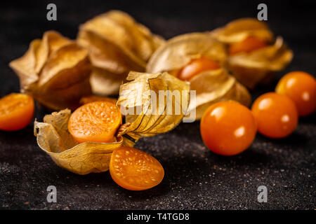 Physalis (Physalis peruviana) ou poha avec calice sur tableau noir Banque D'Images