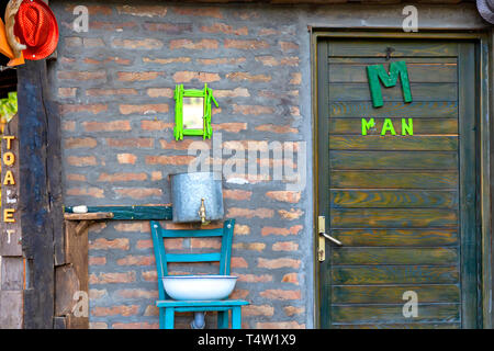 Toilettes et lavabo main métallique et appuyez sur dans le parc. Un WC lavabo blanc ancien vintage. Banque D'Images