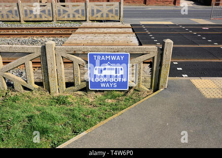 Panneau bleu et blanc du tramway fixé à la clôture en béton et au passage en caoutchouc du train piétonnier sur le tramway de Blackpool sur la côte de fylde dans le Lancashire royaume-uni Banque D'Images