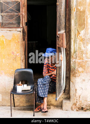 La Havane, Cuba - 25 juillet 2018 : Un homme est assis à la porte de son domicile, la vente de cigares pour gagner un revenu supplémentaire. Banque D'Images