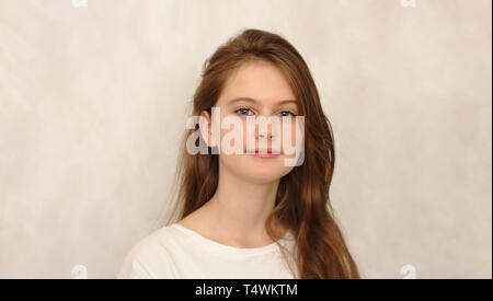 Brune aux yeux bleus jeune fille timide en t-shirt. Modèle de studio photo. Banque D'Images