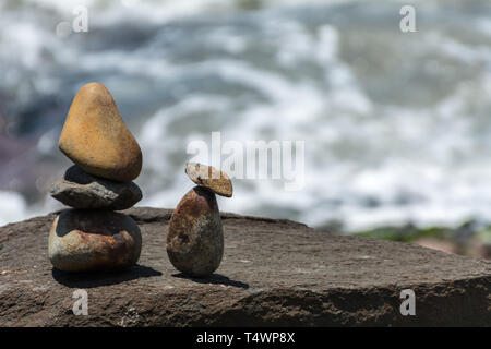 2019, janvier. Florianopolis, Brésil. De petites pierres sculpture ressemblant à deux personnes en face de la mer, sur une région rocheuse. Banque D'Images