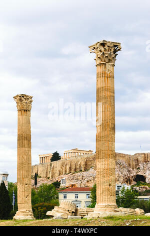 Vue sur l'acropole entre deux piliers du temple de Zeus Olympien nuageux et pluvieux jour à Athènes, Grèce Banque D'Images