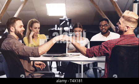 Bon travail. Friendly collègues tapotant poings à travail Banque D'Images