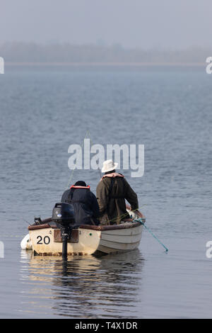 Rugby, Warwickshire / UK - 18 Avril 2019 : Deux pêcheurs dans un petit bateau à moteur hors-bord de l'eau sur l'eau d'un réservoir. Banque D'Images