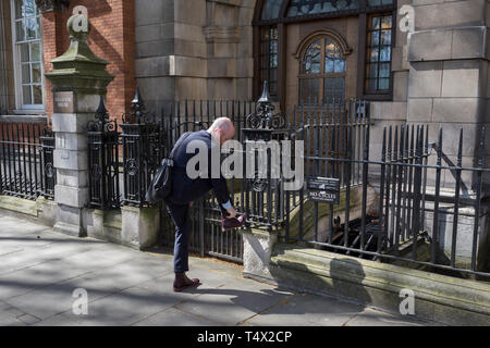 Un homme assiste à un piéton lacet lâche, le 10 avril 2019, à Westminster, London, UK Banque D'Images