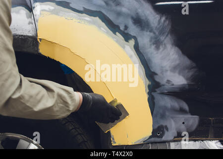 Préparation pour la peinture d'une voiture à l'aide de l'élément capteur d'émeri un technicien de nivellement avant l'application d'un primaire après l'endommagement d'une partie de l'adm. Banque D'Images