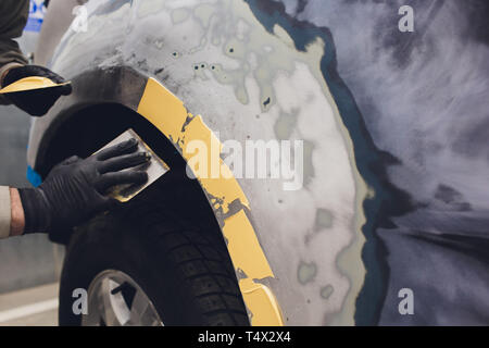 Préparation pour la peinture d'une voiture à l'aide de l'élément capteur d'émeri un technicien de nivellement avant l'application d'un primaire après l'endommagement d'une partie de l'adm. Banque D'Images