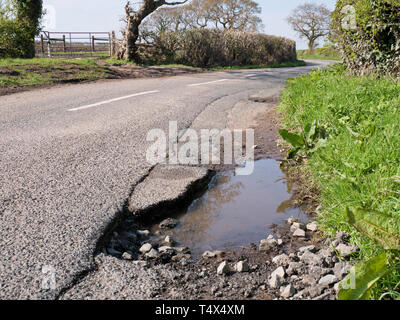 Dommages à la surface non réparés tarmac sur une route rurale Banque D'Images