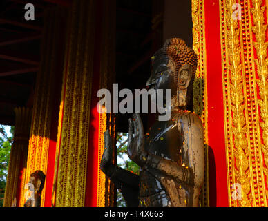 Statues de Bouddha d'arrosage avec l'eau parfumée et de pétales de fleurs au cours de la nouvelle année - Mai Rp - Lao Song Kran - Fête de l'eau en Avril Banque D'Images