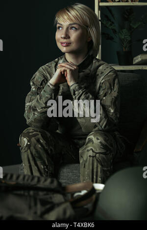 En attendant de rentrer chez eux, à rêver de confort familial. Portrait de femme soldat. Femme en uniforme militaire pendant la réunion avec le psychothérapeute de réadaptation psychologique et le traitement du SSPT. Banque D'Images