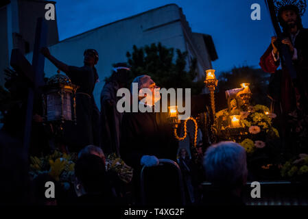 Un adorateur place une bougie quelques instants avant de prendre part à la Procession du Silence pour Jeudi Saint à Badalona pendant la Semaine Sainte. Le processus Banque D'Images