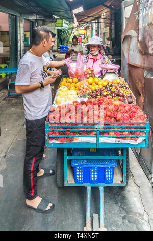 Bangkok, Thaïlande - 31 janvier 2019 : vendeur de fruits avec le client dans une ruelle dans le quartier chinois. Fruit est un snack populaire. Banque D'Images