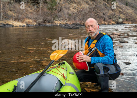 Portrait de l'environnement d'un pagayeur en gilet avec un whitewater kayak gonflable - Powder River, Colorado au début du printemps Banque D'Images