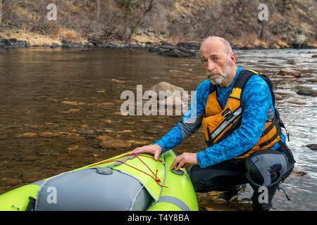 Portrait de l'environnement d'un pagayeur en gilet avec un whitewater kayak gonflable - Powder River, Colorado au début du printemps Banque D'Images