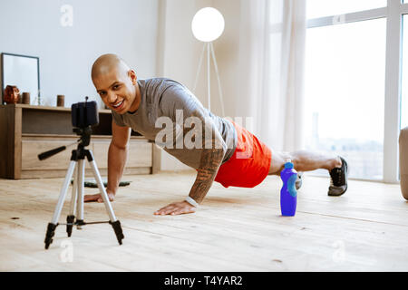 Bald sportsman faisant pompes lors d'un tournage matin tutoriel Banque D'Images