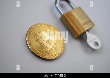 Concept de sécurité Bitcoin. Pièce d'or avec un cadenas sur un fond clair.. Banque D'Images