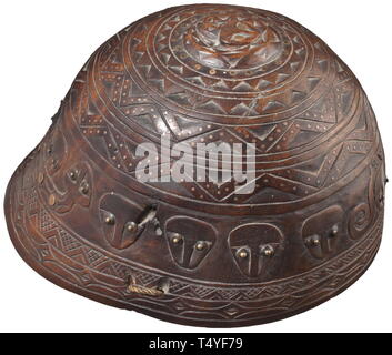 Un casque en bois sculpté, chinois/taiwanais, 19e siècle. Casque d'une seule pièce de bois dur fait. L'extérieur Entièrement sculpté avec des visages stylisés, décorations géométriques ainsi qu'un serpent sur la plaque de la couronne. Plusieurs lignes continues de cuivre et laiton incrusté de pins, certains d'entre eux sur fond corne disques. Deux mentonnière tressé attaché au casque. Diamètre 20 cm.  + + historique, historique, de la Chine, Chinois, 19e siècle, Additional-Rights Clearance-Info-Not-Available- Banque D'Images