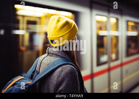 Jeune femme attend à la station de métro tandis que le train arrrives. Transports et déplacements concept. Banque D'Images