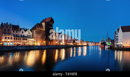 Vieille ville de Gdansk, Pologne la nuit. Rivière avec la célèbre Grue et réflexions de la ville dans la rivière Motlava. Panorama haute résolution. Banque D'Images