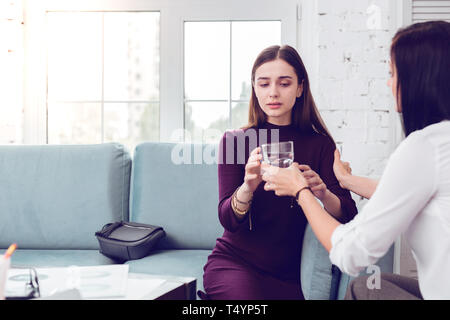 Psychologue professionnel donnant un verre d'eau de dame. Banque D'Images