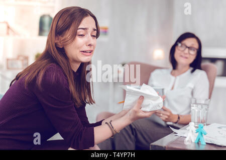 Pleurer en colère jeune dame brune passe au cours de la thérapie émotionnelle physiologique. Banque D'Images