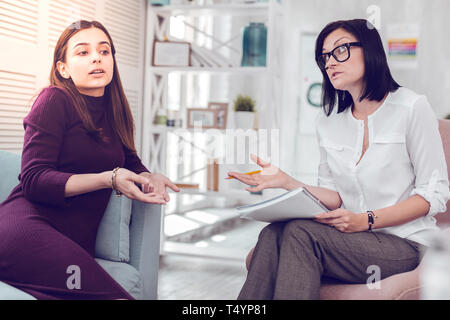 Beaux jeunes-adultes dame discutant des problèmes de relations avec un psychologue. Banque D'Images