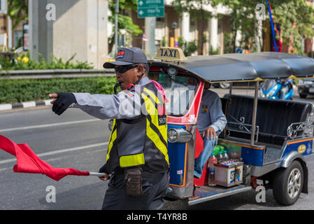 Diriger la circulation dans le centre Marshall sur la ville de Bangkok en Thaïlande avec un tuk tuk à l'arrière-plan sur une rue animée dans le centre de la ville. Banque D'Images