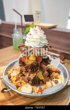 Glace au chocolat gaufre avec divers fruits et fouetter la crème sur bac zinc Banque D'Images