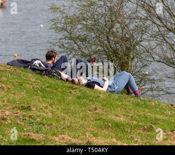 Jeune couple dans un parc, se détendre au soleil au bord de la mer. Banque D'Images