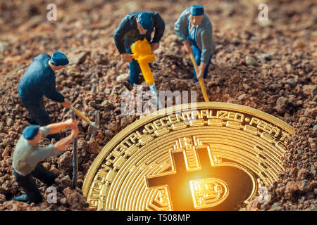 Figurines mineur macro creusant pour découvrir grand bitcoin brillant Banque D'Images