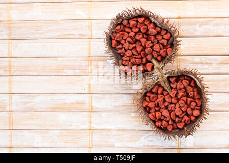 Graines de rocou sur bois rustique, vue du dessus Banque D'Images