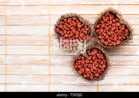 Graines de rocou sur bois rustique, vue du dessus Banque D'Images