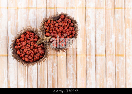 Graines de rocou sur bois rustique, vue du dessus Banque D'Images
