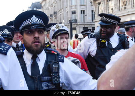 Londres, Royaume-Uni. 18 avril 2019. Les agents de police à l'arrestation du militant dernier (C) de la voile rose à Oxford Circus pendant 'London : rébellion internationale', sur cinq jours d'une manifestation organisée par l'extinction de la rébellion. Les manifestants exigent que les gouvernements prennent des mesures contre le changement climatique. La police a émis une ordonnance exigeant que l'article 14 les protestataires à convoquer à Marble Arch que pour que la protestation peut continuer. Crédit : Stephen Chung / Alamy Live News Banque D'Images